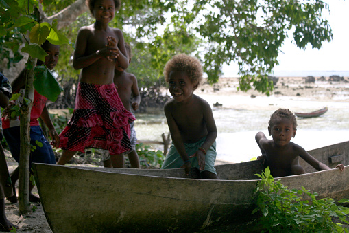Small Gela, Central Province, Solomon Islands - May 22, 2016: Children are playing in a canoe on Small Gela island.