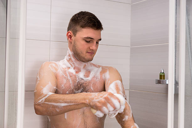 istock Bare man rubbing himself a foam sponge bath in shower 624701184