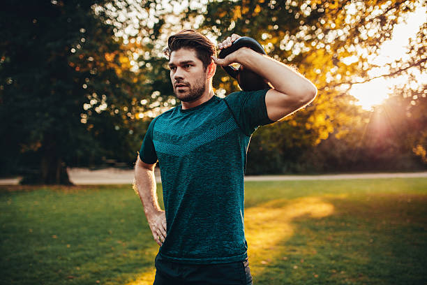 istock Tough young guy exercising with kettlebell in park 624701558