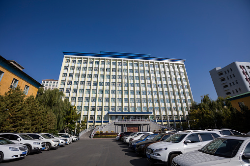 Uurumqi, Xinjiang, China - October 10, 2016: Campus view of the Teaching building on the background, and cars on the sides.