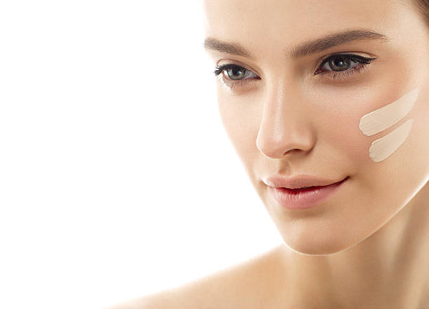 Perfect makeup. Skin tone cream lines on woman face. Skin tone cream lines on woman face. Beautiful woman portrait beauty skin healthy and perfect makeup. Studio shot. Isolated on white. liquid foundation face stock pictures, royalty-free photos & images
