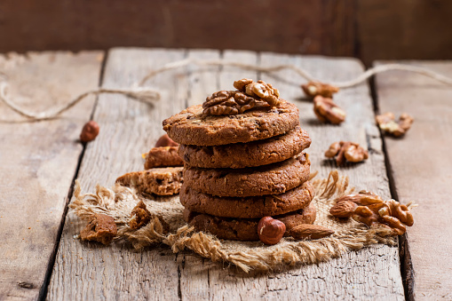 Chocolate cookies with nuts, vintage wooden background, selective focus