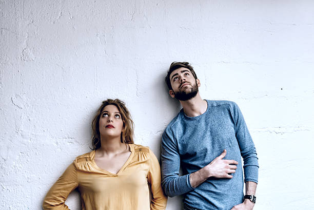 young man and woman looking up in the air young handsome man and beautiful woman looking up in the air two people thinking stock pictures, royalty-free photos & images