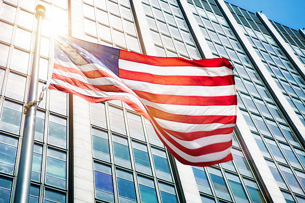 drapeau américain flottant devant une éruption solaire d’un immeuble de bureaux - san francisco county flash photos et images de collection