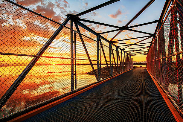istock steel walking bridge by the sea at sunset time 624714466