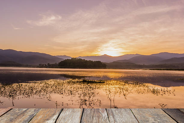 istock Wood table top on lake at sunrise 624716434