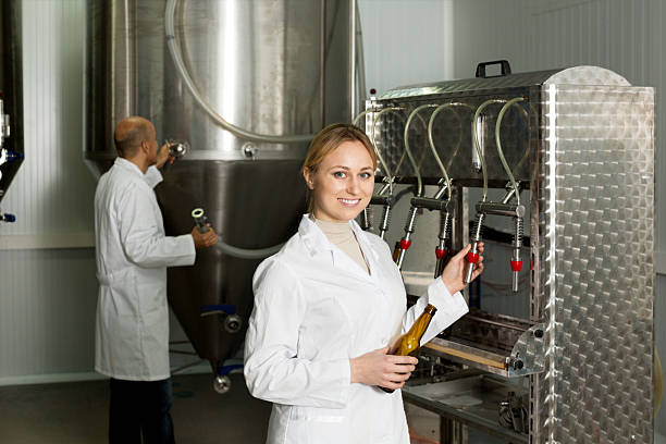 istock Smiling female brewery worker with bottling machinery 624716598