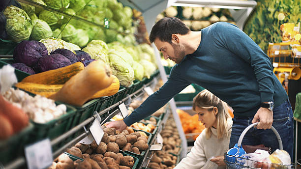 pareja en supermercado comprar verduras. - supermarket shopping retail choice fotografías e imágenes de stock