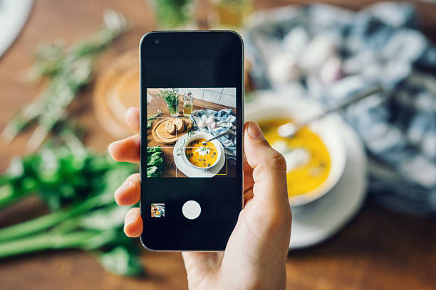 mujer tomando foto de sopa de calabaza con smartphone - mensaje de móvil fotografías e imágenes de stock