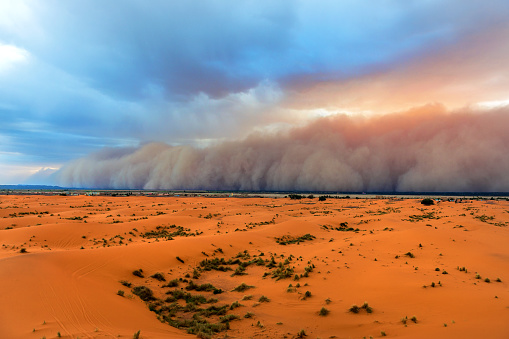 Sandstorm comming fast towards Merzouga in Erg Chebbi Desert, Morocco, Africa. Thin green line is the settlement.Nikon D3x