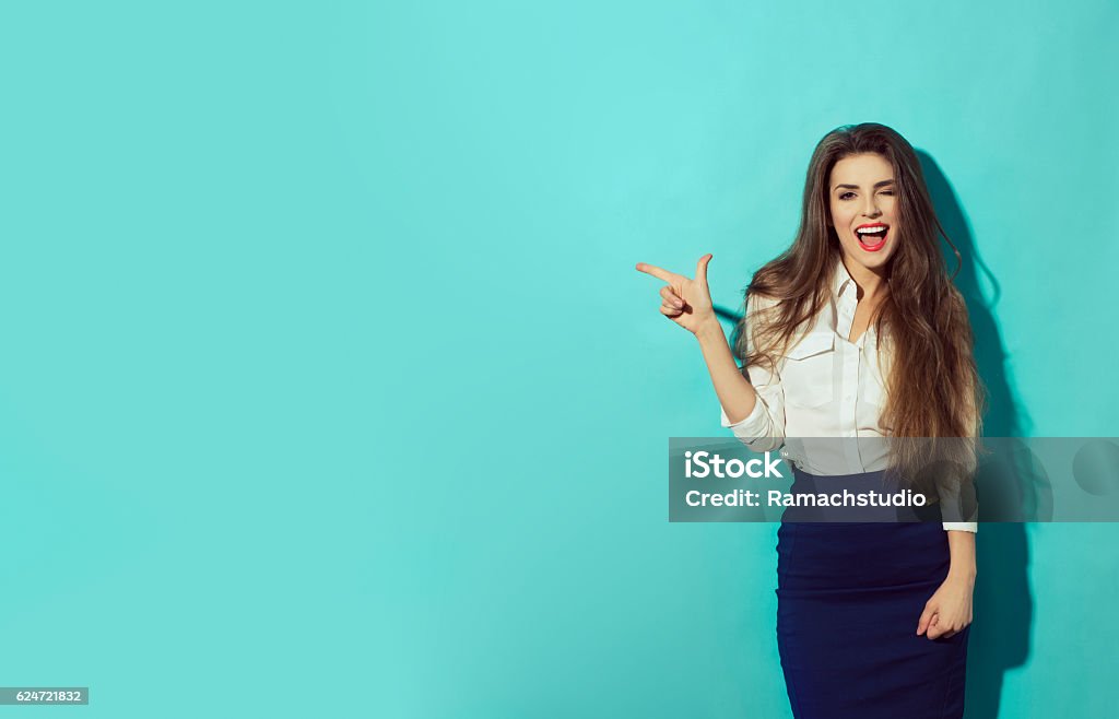 woman let eyelet and pointing with finger to the left Beautiful woman let eyelet and pointing with finger to the left. Paste text. Women Stock Photo