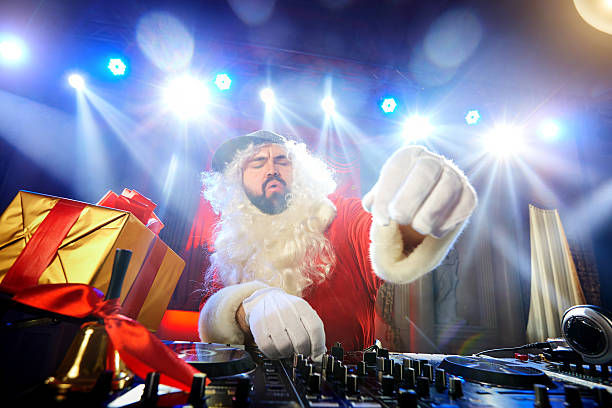 dj père noël mélangeant un événement de noël.  lumière disco - santa claus audio photos et images de collection