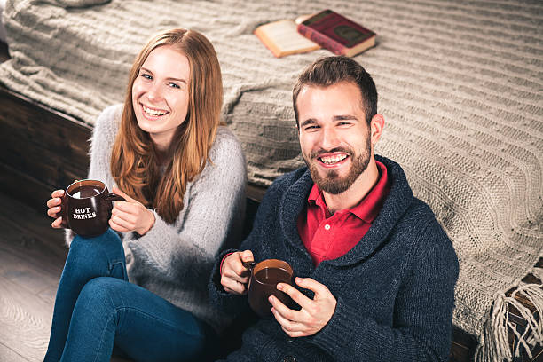 молодая пара на дому - brick red wool heat стоковые фото и изображения