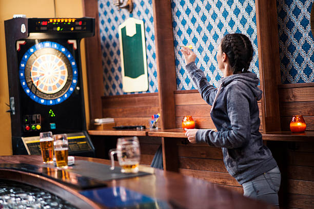 Girl playing darts at bar