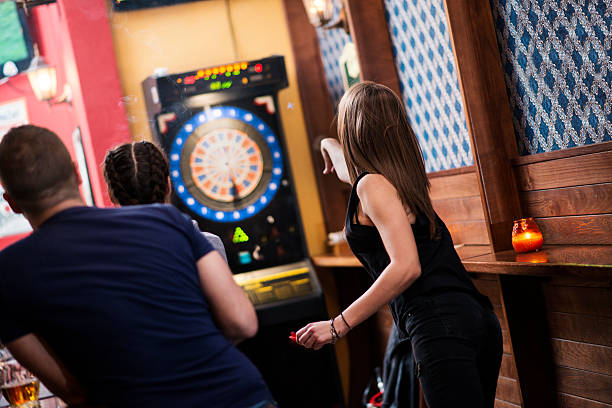 amigos jugando a los dardos en un club - dartboard darts scoreboard leisure games fotografías e imágenes de stock