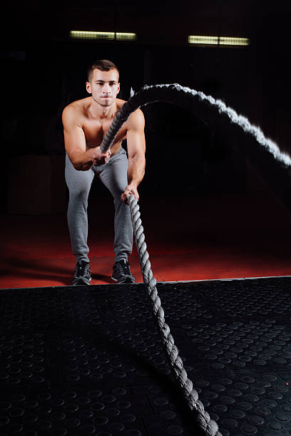 istock Men with battle rope in functional training fitness gym 624739876