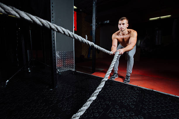 istock Men with battle rope in functional training fitness gym 624740004
