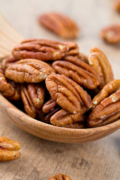 istock pecan nuts in a wooden spoon 624742284