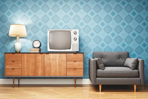 Living room decorated in retro style with TV stand, armchair and old television.