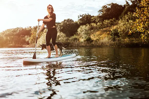Photo of Paddleboarding Woman With Dog