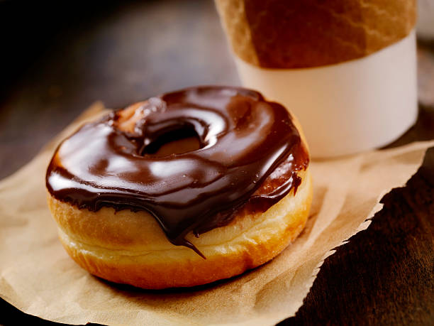 Chocolate Donut Chocolate Donut with a Take Out Coffee- Photographed on Hasselblad H3D2-39mb Camera donuts stock pictures, royalty-free photos & images