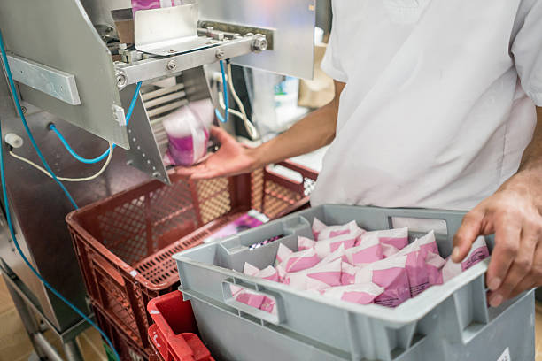 People working at a food factory making dairy products - food industry concepts