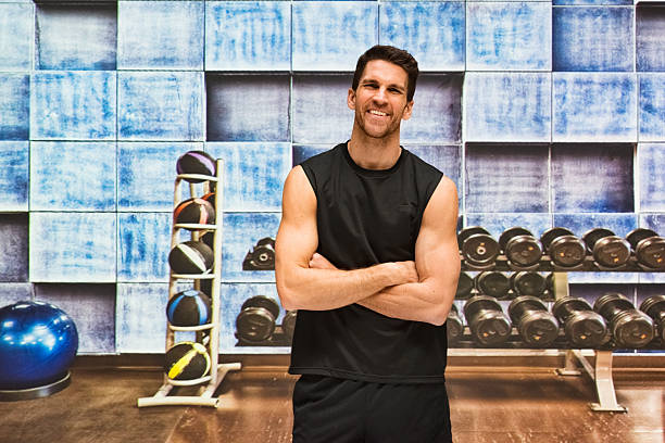 istock Smiling muscular man standing in gym 624747568
