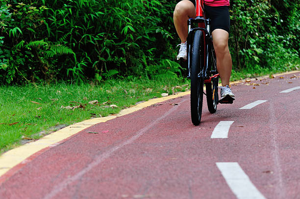 people legs cycling on trail at park