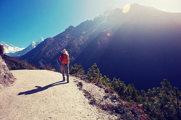 Backpacking woman photographer on high altitude mountain top
