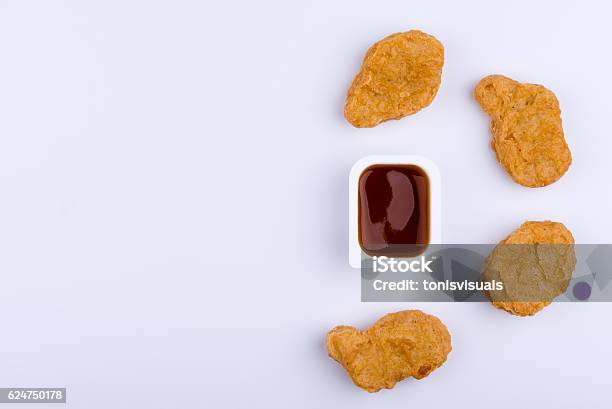 Dip Sauce In Plastic Container And By Four Chicken Nuggets Stock Photo - Download Image Now