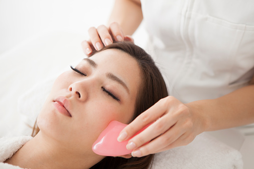 Woman receiving face massage for health