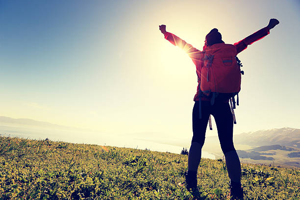 istock cheering successful woman backpacker open arms on mountain peak 624750810