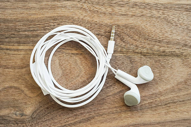 istock white earphones on wood, top view 624752402