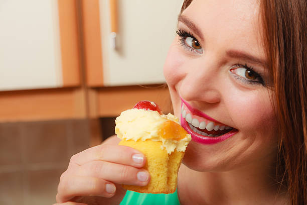 Woman eating delicious cake with sweet cream and fruits on top. Appetite and gluttony concept.