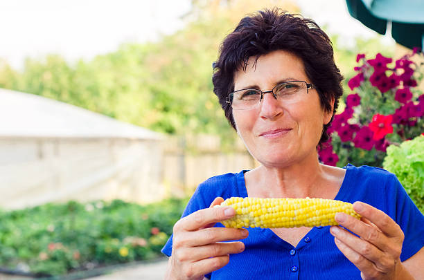 istock Woman eating boiled sweet corn 624848612