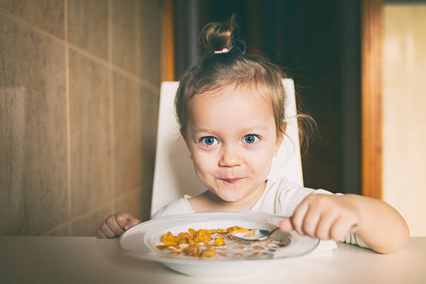 istock Little girl eating corn flakes 624848648
