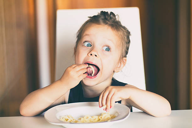 istock Little girl eating pasta 624848904