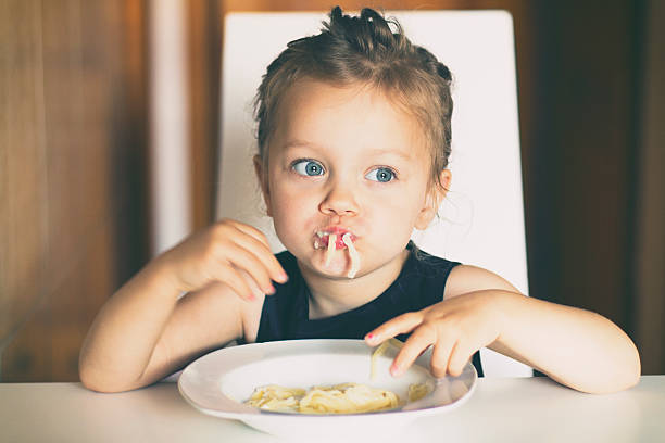 istock Little girl eating pasta 624849068