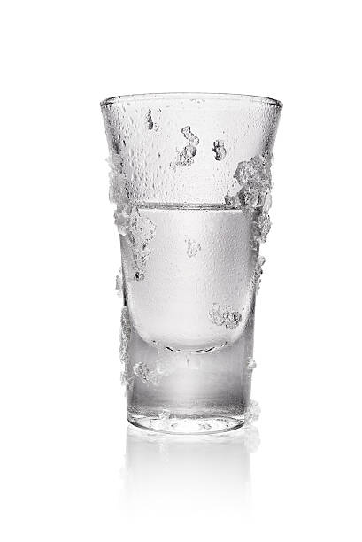 Glass of vodka isolated Glass of vodka with ice crystals isolated on white background with clipping path shot glass stock pictures, royalty-free photos & images