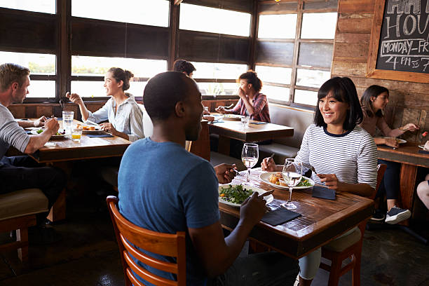 istock Mixed race couple enjoying lunch in a busy restaurant 624851590