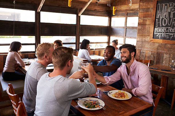 istock Four male friends making a toast at a table in a restaurant 624851658