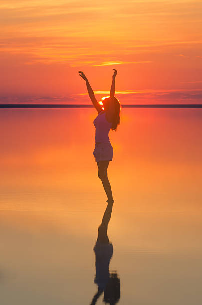 istock Beautiful female model open arms under sunset at seaside 624852148