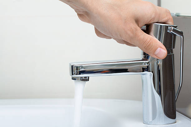 man hand on water tap stock photo
