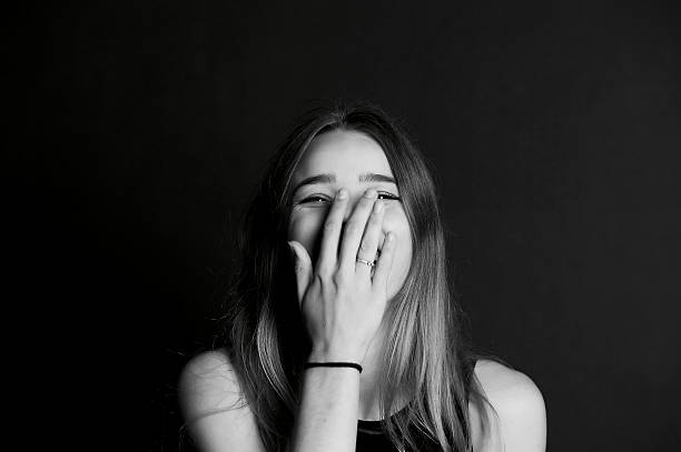 istock beautiful young girl laughs and closes  hand  face. 624856242