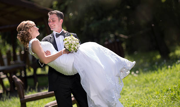 istock Groom carrying bride outdoors 624856290