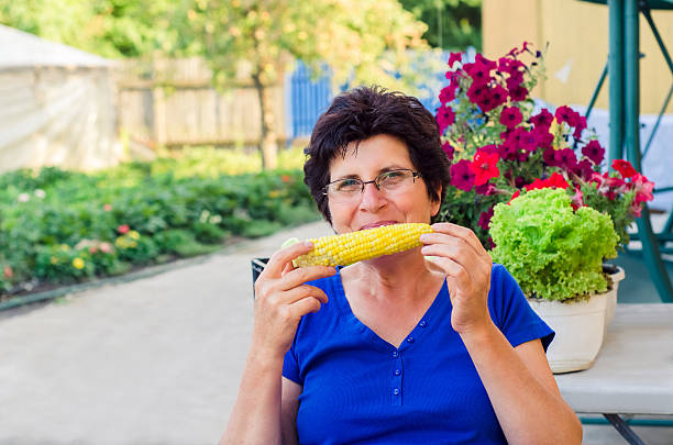istock Woman eating sweet corn 624867374