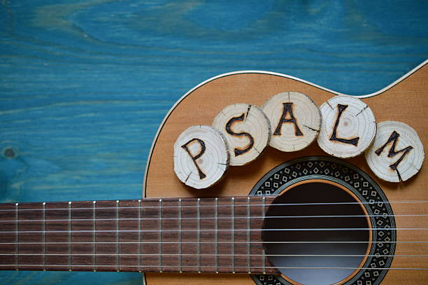 guitar on teal wood and the word: PSALM guitar on teal wooden background with wood pieces on it lettering the word: PSALM sing praise stock pictures, royalty-free photos & images