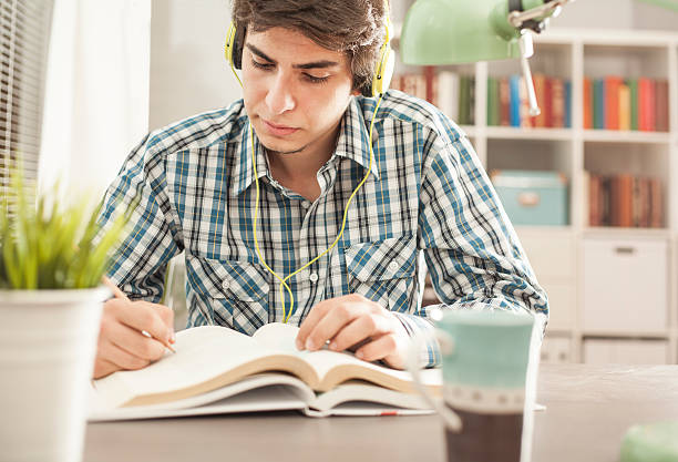 istock Portrait of young man reading book 624867776