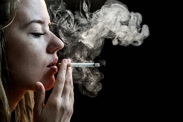 istock Woman Smoking a dangerous Cigarette on Black Background 624868682