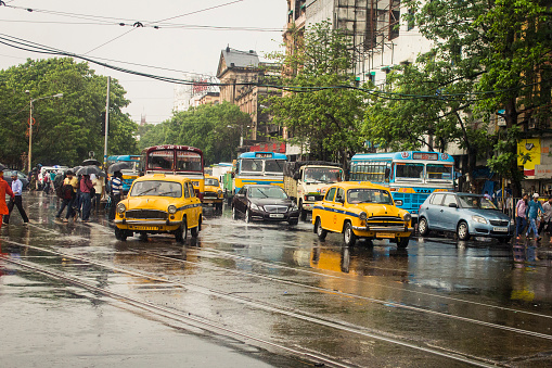 This is a typical monsoon afternoon in Kolkata. It was still raining while I ttok the picture so in the picture people are crossing the streets with umbrelas.  Shot near Esplande street in Kolkata.